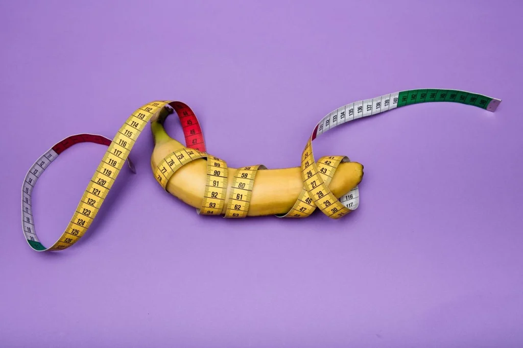 Banana wrapped with measuring tape representing dildo sizing and shape guide