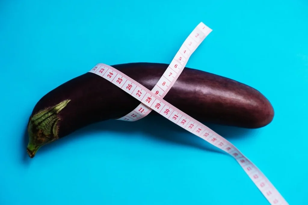 Eggplant wrapped in a measuring tape, a lighthearted way to illustrate size and fit
